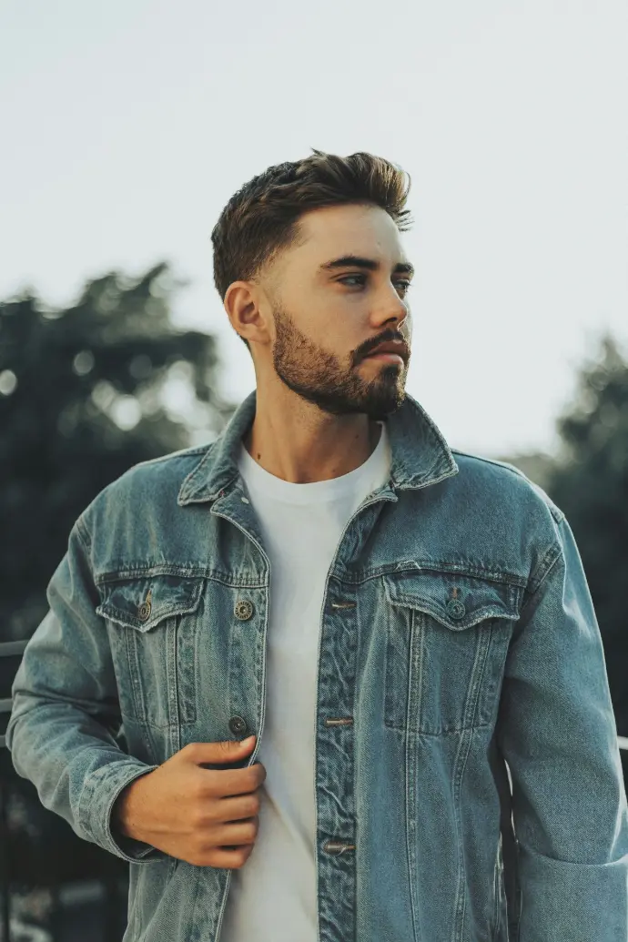a man with a beard wearing a denim jacket